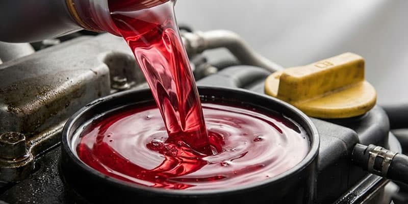 vertiendo hidrolina en un envase de un auto