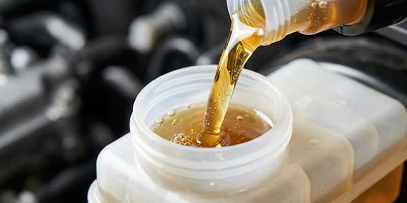 añadiendo liquido de freno en un envase dot 3 en un auto