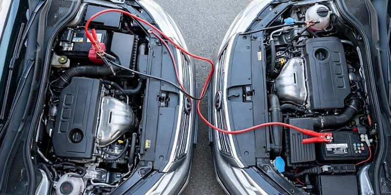 auto frente con otro auto para pasar corriente de una bateria cargada a otra bateria descargada